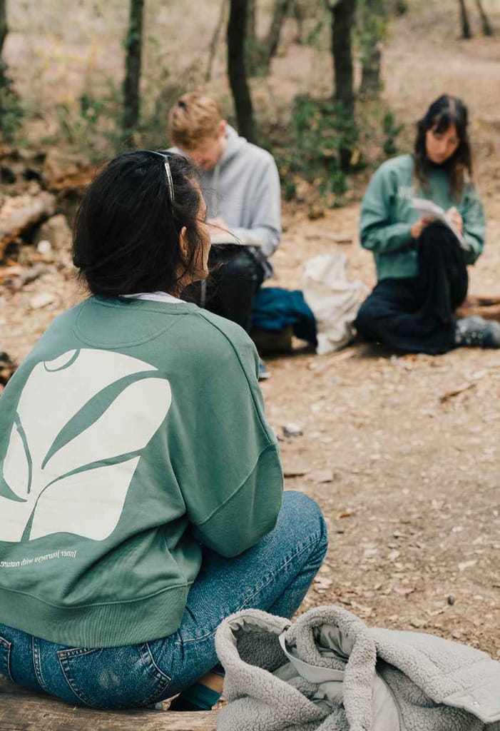 A group of people sitting in a circle in an outdoor setting